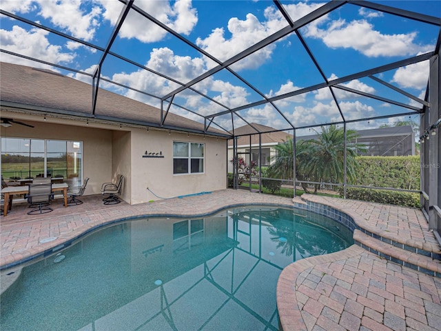 pool featuring glass enclosure and a patio