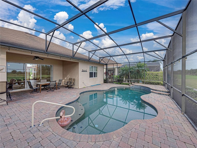 pool with a lanai, a patio area, and ceiling fan