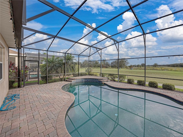 outdoor pool featuring a patio area, glass enclosure, and a jacuzzi