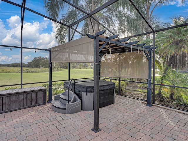 view of patio with glass enclosure and a hot tub