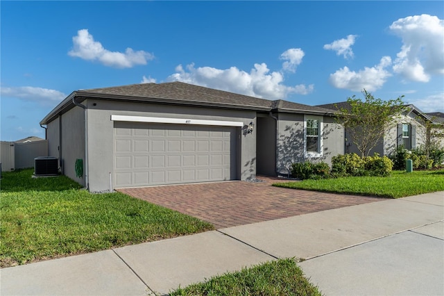 view of front of house featuring a garage, a front lawn, and cooling unit