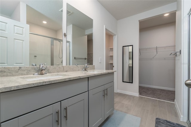 bathroom featuring a textured ceiling, hardwood / wood-style floors, vanity, and an enclosed shower