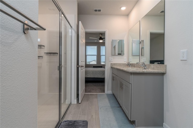 bathroom with wood-type flooring, vanity, ceiling fan, and a shower with shower door