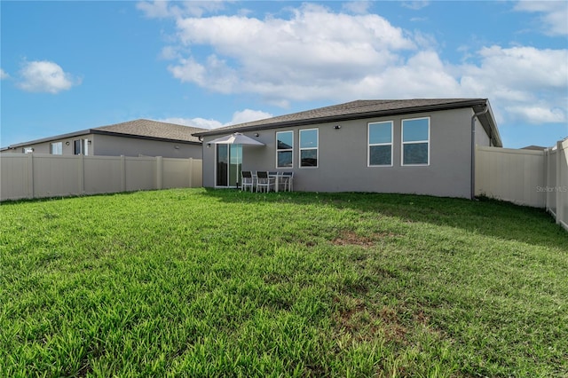 back of property featuring a lawn