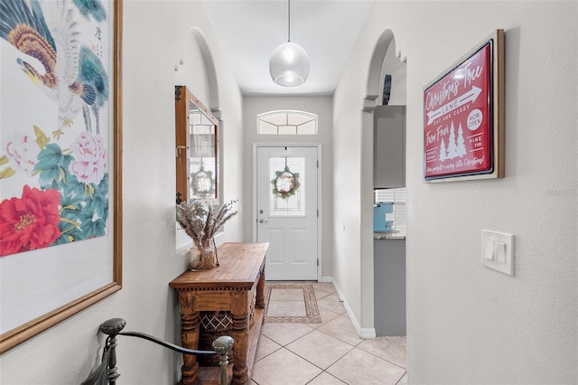 foyer entrance featuring light tile patterned floors and vaulted ceiling