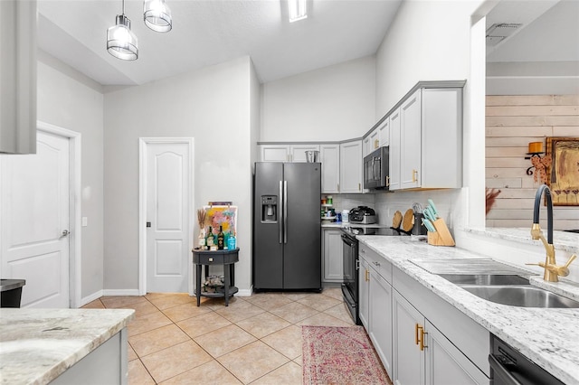 kitchen with light stone countertops, sink, black appliances, and lofted ceiling