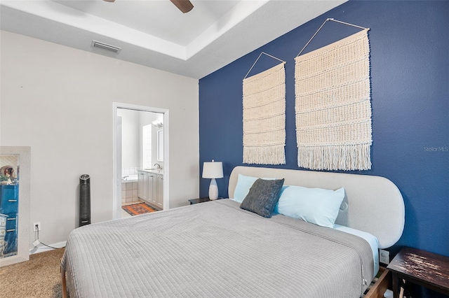 bedroom with carpet flooring, ensuite bathroom, and ceiling fan