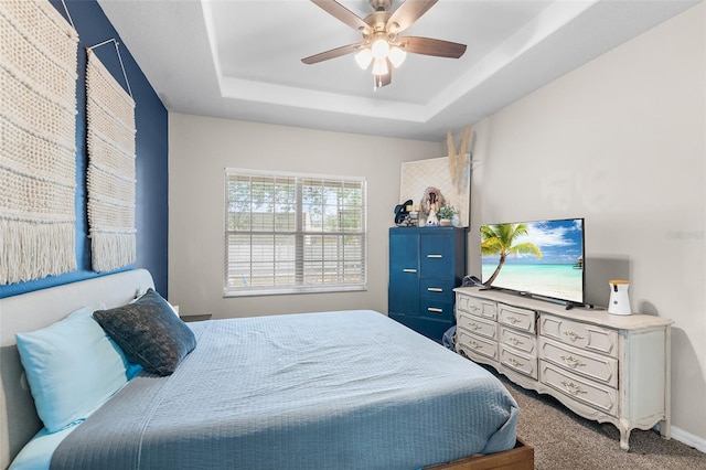 bedroom featuring carpet floors, a raised ceiling, and ceiling fan