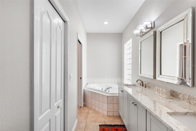 bathroom featuring vanity, tile patterned floors, and tiled tub