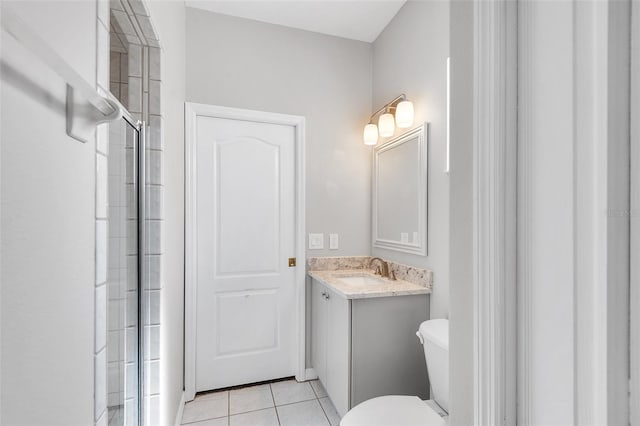 bathroom with tile patterned flooring, vanity, toilet, and walk in shower