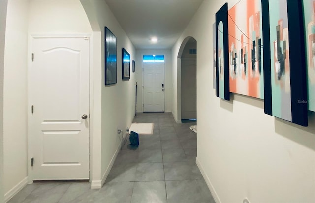 535 Noble Ave, Davenport, FL 33837 - hall featuring arched walkways, light tile patterned floors, and baseboards