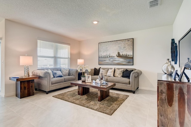 living room featuring a textured ceiling and light tile patterned flooring