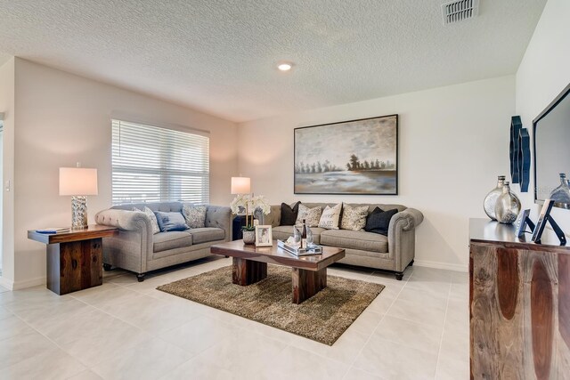 535 Noble Ave, Davenport, FL 33837 - living room featuring a textured ceiling, light tile patterned floors, and baseboards