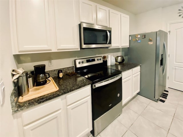 535 Noble Ave, Davenport, FL 33837 - kitchen with appliances with stainless steel finishes, white cabinets, light tile patterned floors, and dark stone countertops