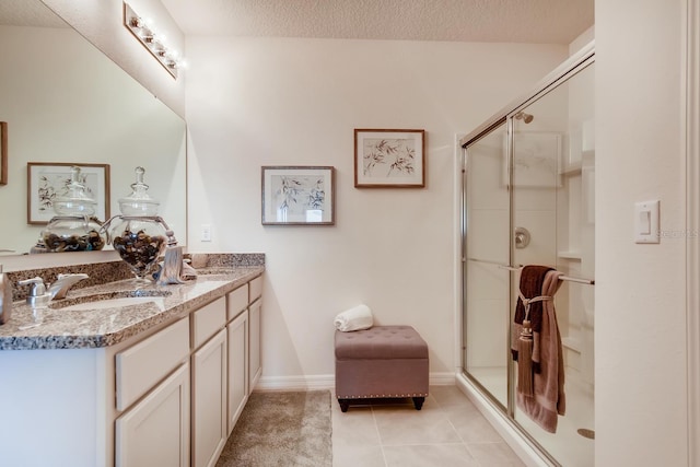 bathroom featuring vanity, walk in shower, tile patterned flooring, and a textured ceiling