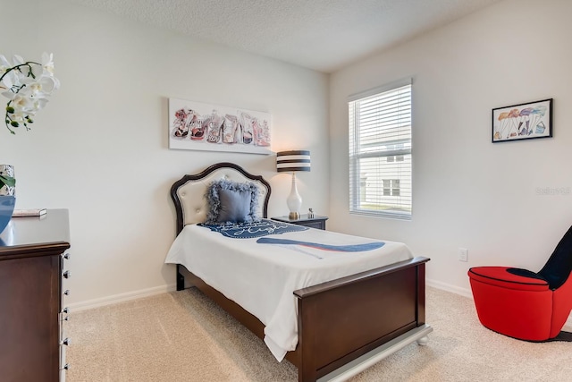 bedroom with a textured ceiling and light colored carpet