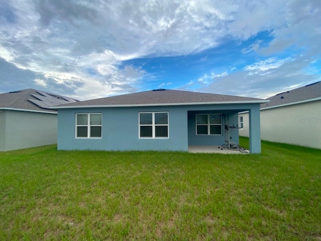 535 Noble Ave, Davenport, FL 33837 - rear view of house with a lawn, stucco siding, and a patio area
