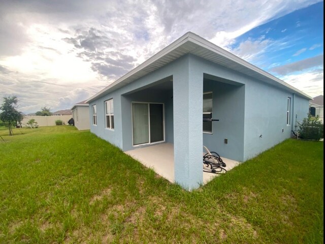535 Noble Ave, Davenport, FL 33837 - back of property with a patio, stucco siding, and a lawn