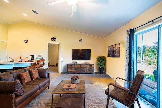 living room with ceiling fan, light hardwood / wood-style floors, and lofted ceiling