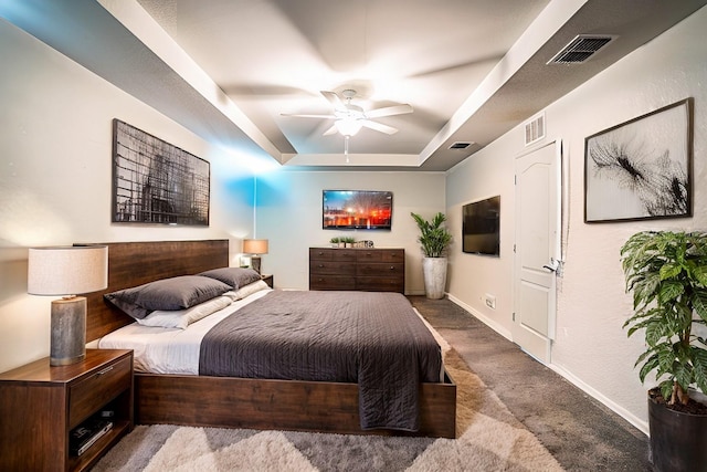 bedroom with a tray ceiling, ceiling fan, and carpet