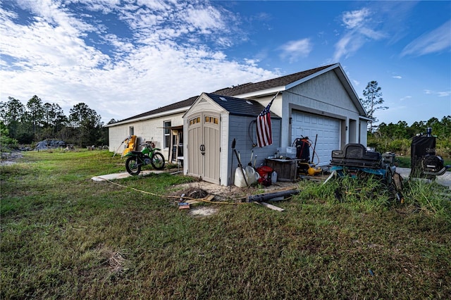 view of side of property featuring a garage, an outdoor structure, and a lawn