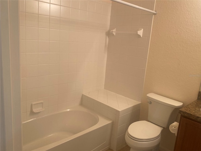 full bathroom featuring vanity, tiled shower / bath combo, and toilet