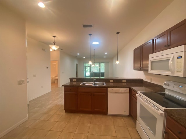 kitchen with kitchen peninsula, white appliances, sink, light tile patterned floors, and decorative light fixtures