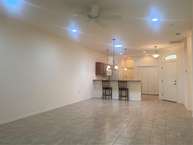 unfurnished living room with sink, ceiling fan, and light tile patterned flooring