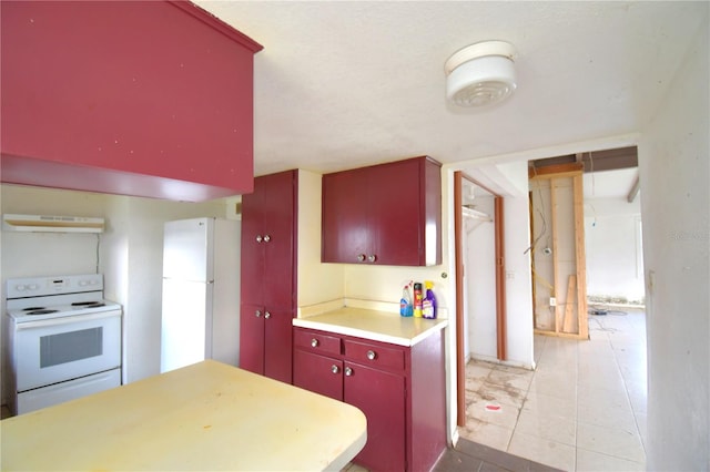 kitchen with light tile patterned floors, white appliances, and range hood