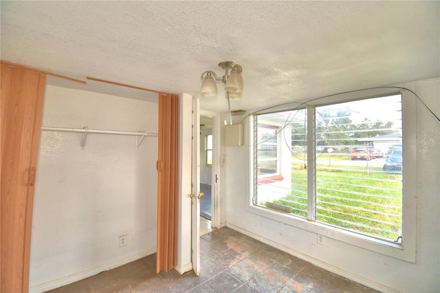 unfurnished bedroom with a textured ceiling and a closet