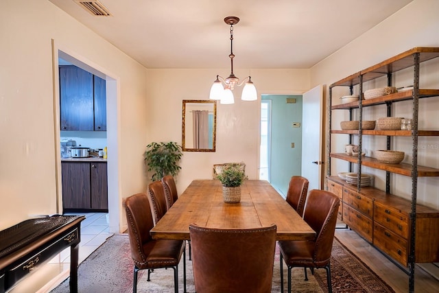 dining room with a chandelier and light tile patterned floors