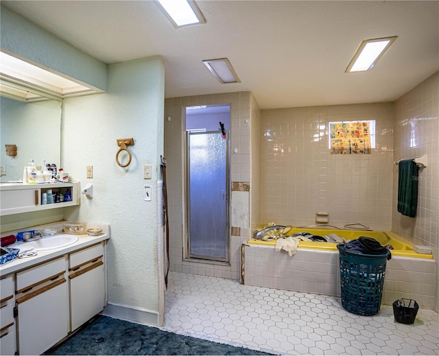 bathroom featuring tile patterned floors, vanity, and shower with separate bathtub