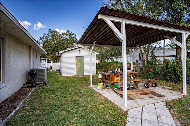 view of yard featuring a patio, central AC, and a storage unit