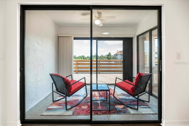 sitting room with ceiling fan and a textured ceiling