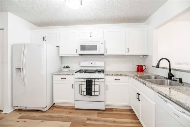 kitchen with sink, light hardwood / wood-style floors, white appliances, decorative backsplash, and white cabinets