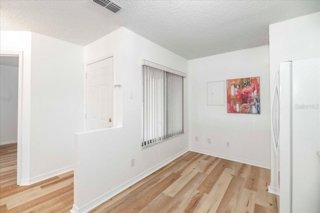 empty room featuring light hardwood / wood-style floors and a textured ceiling