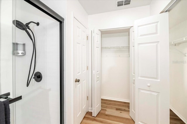 interior space with hardwood / wood-style floors and an enclosed shower