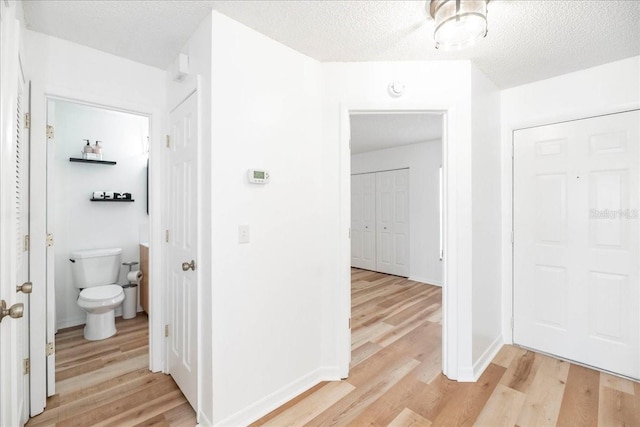 bathroom featuring wood-type flooring, a textured ceiling, and toilet