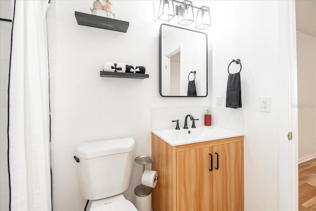 bathroom with hardwood / wood-style floors, vanity, and toilet