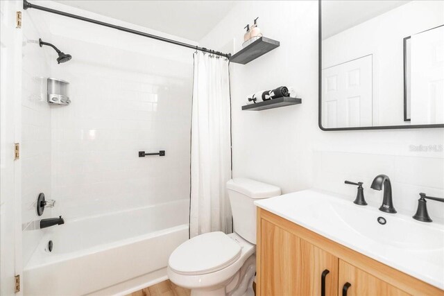 full bathroom with vanity, shower / bath combination with curtain, and toilet