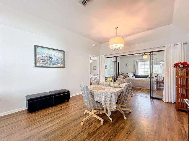 dining space featuring ceiling fan with notable chandelier and wood-type flooring