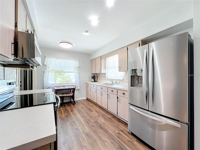 kitchen featuring hardwood / wood-style flooring, backsplash, sink, and appliances with stainless steel finishes