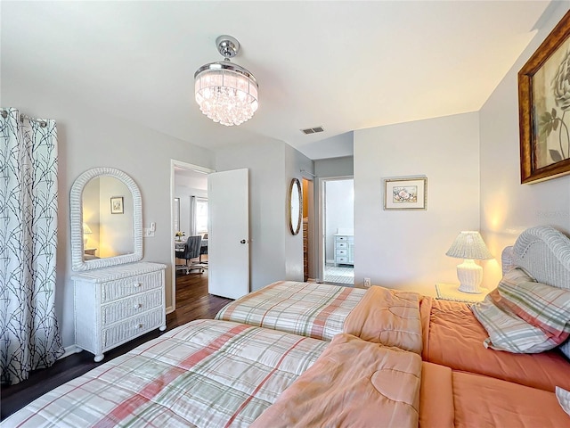 bedroom with dark hardwood / wood-style flooring and a notable chandelier