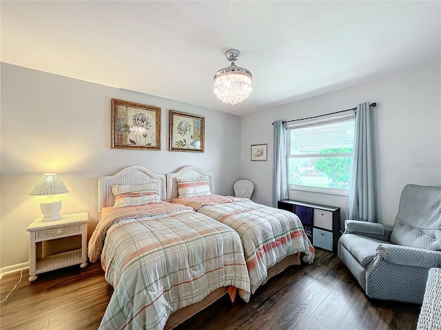 bedroom featuring dark hardwood / wood-style floors and an inviting chandelier