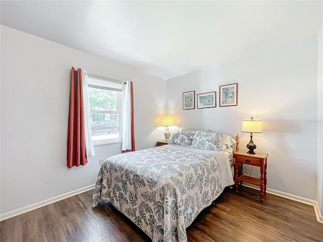 bedroom with dark hardwood / wood-style floors