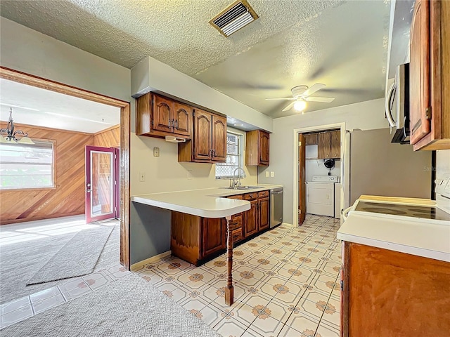 221 Dorothy St, Auburndale, FL 33823 - kitchen with stainless steel appliances, light countertops, ceiling fan, a textured ceiling, and brown cabinetry