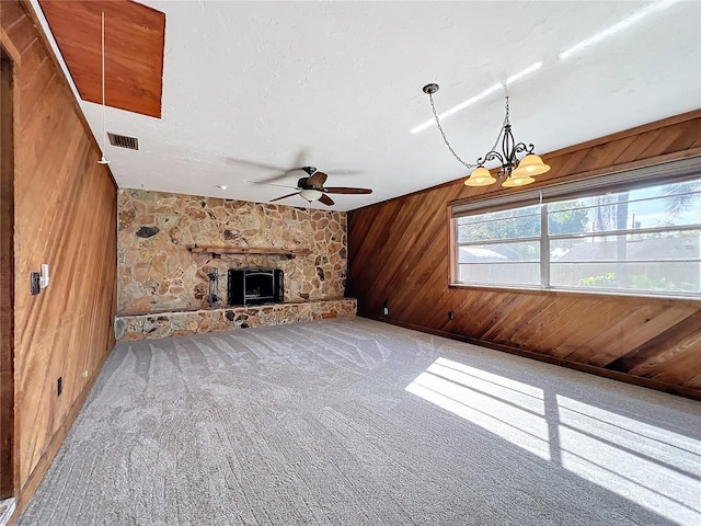 221 Dorothy St, Auburndale, FL 33823 - unfurnished living room featuring wood walls, ceiling fan, carpet, a fireplace, and a chandelier