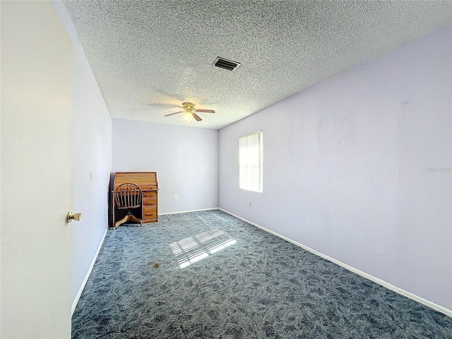 empty room featuring ceiling fan, carpet, and a textured ceiling