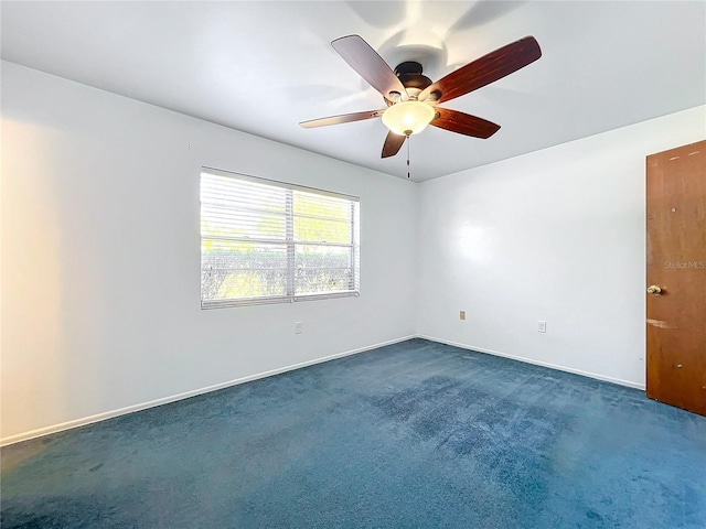 spare room with dark carpet and ceiling fan