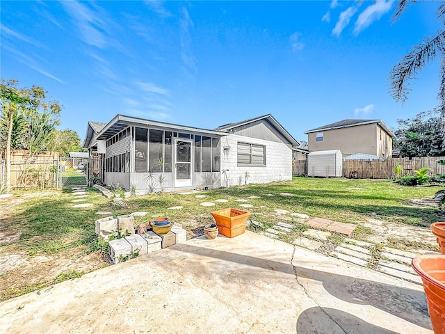 221 Dorothy St, Auburndale, FL 33823 - rear view of property with a sunroom, a patio, a gate, a fenced backyard, and a storage shed